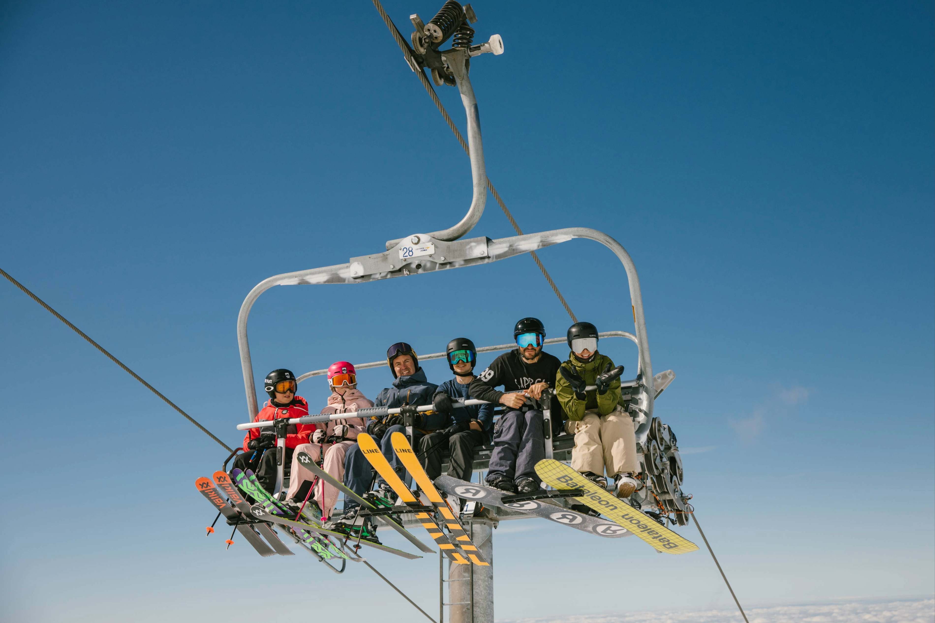 Skiers riding a chairlift at Mt Hutt on a sunny spring day
