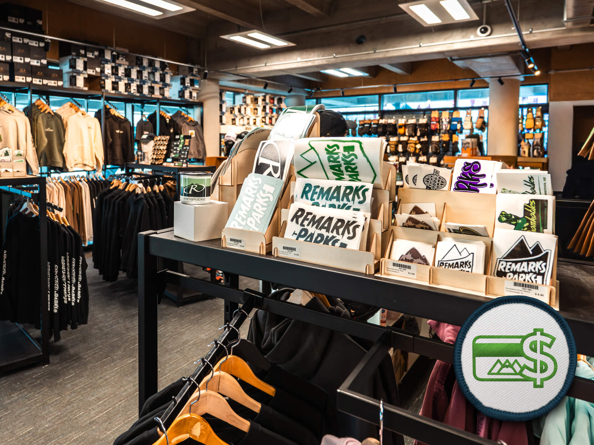 Remarkables retail store interior showing racks of hoodies and shelves of stickers with 'Remarks Parks' branding.